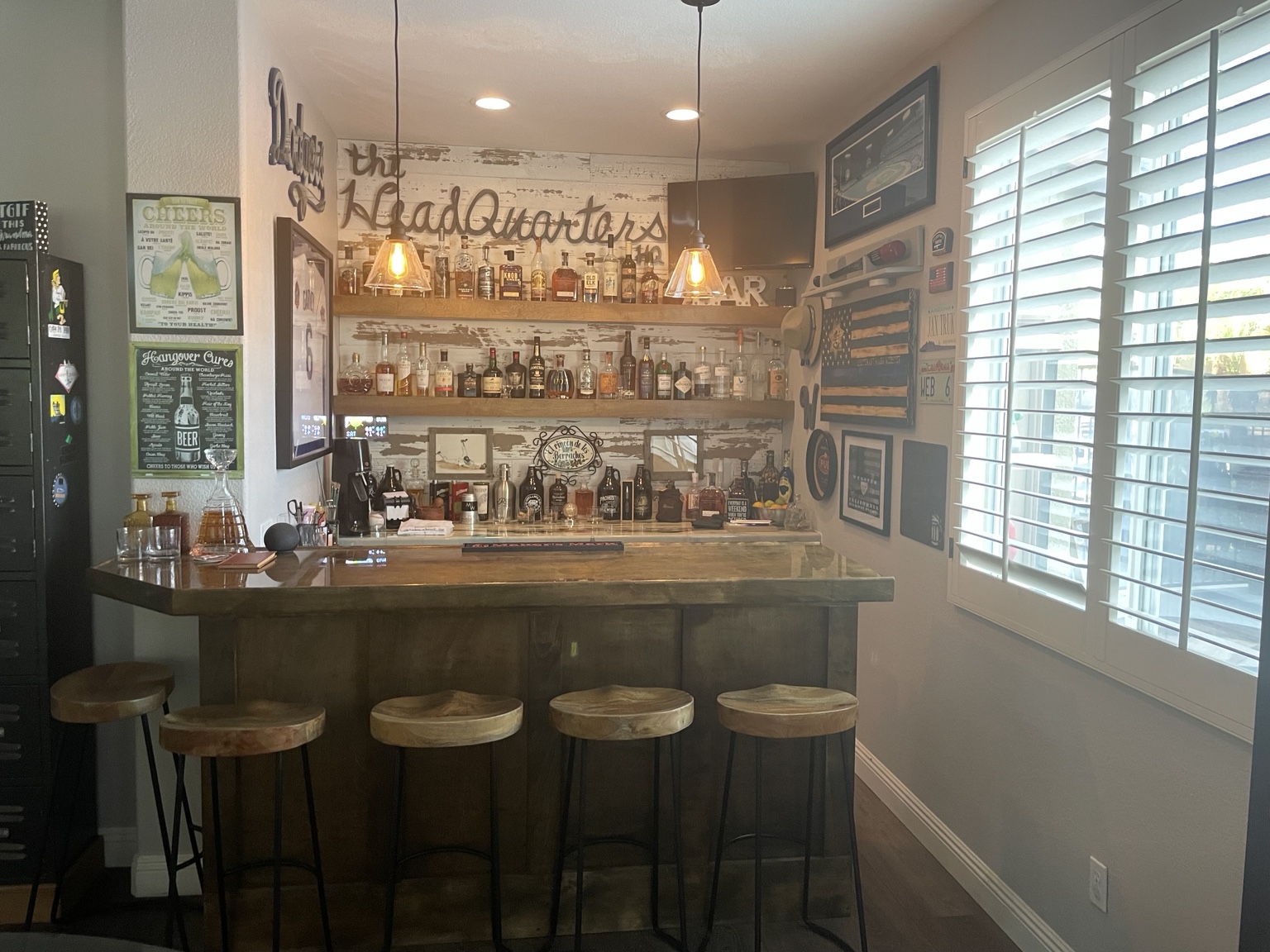 The Headquarters family bar with wooden stools, glowing pendant lights and bottle shelves
