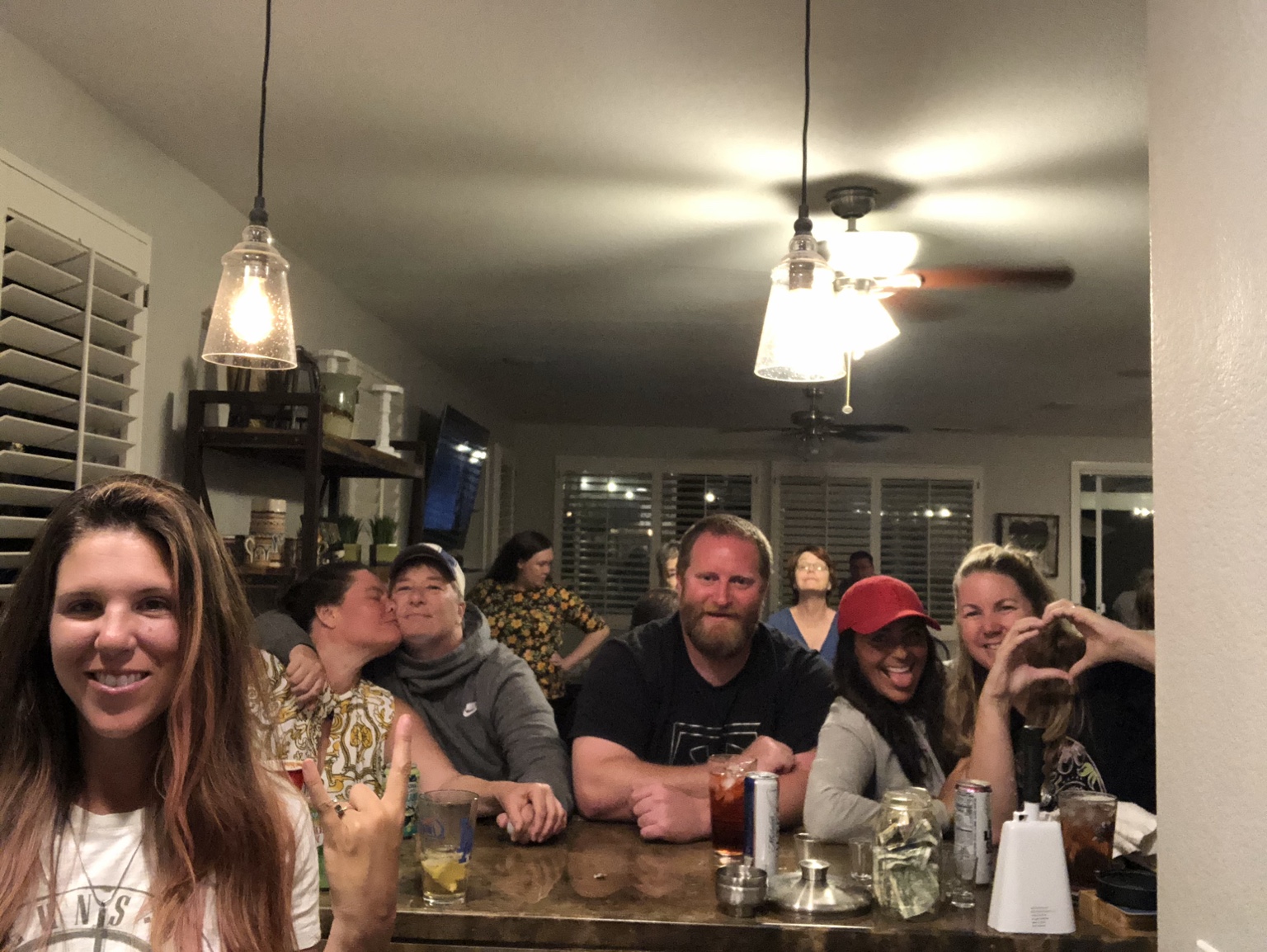 Family and friends smiling together around the Headquarters bar